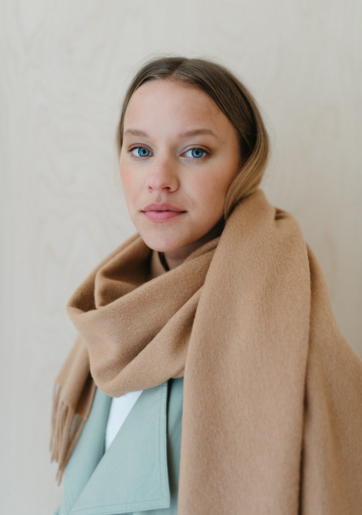 TBCo Lambswool Oversized Scarf in Camel styled as wrap against mint green coat, showing soft texture and generous draping
