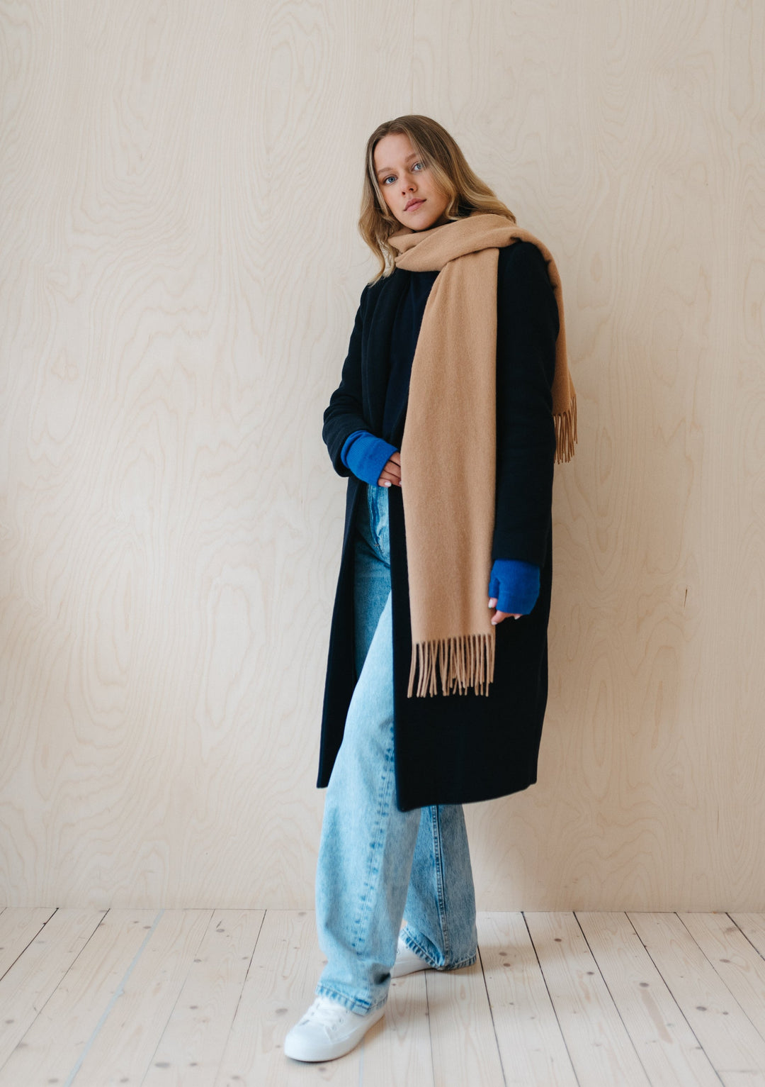 TBCo Lambswool Scarf in Camel draped elegantly over black winter coat, showcasing soft texture and classic fringed design