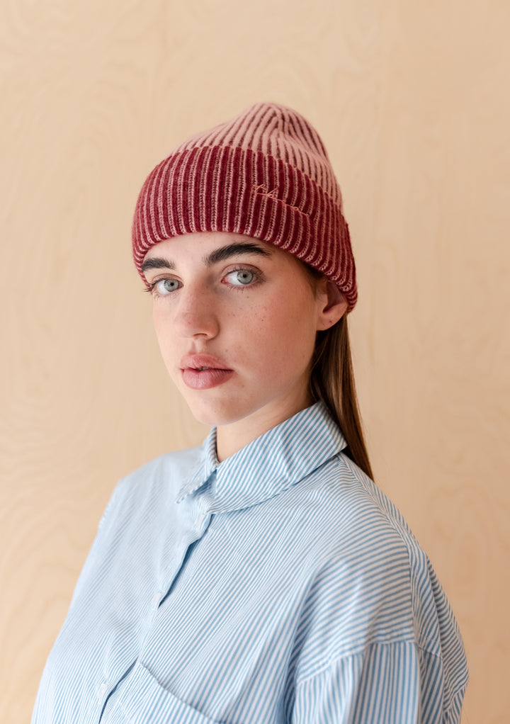 Woman wearing a Cashmere & Merino Two-Tone Beanie in Pink by TBCo, featuring ribbed knit and embroidered logo