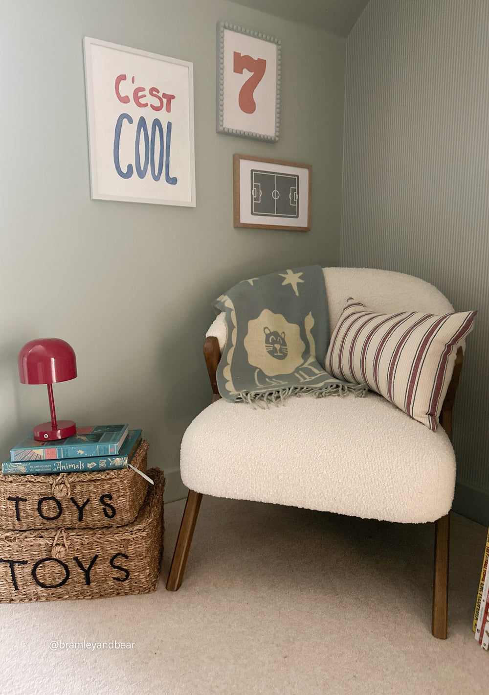 TBCo Lambswool Baby Blanket in Circus Jacquard draped over a cosy chair with striped cushion in a stylish nursery corner