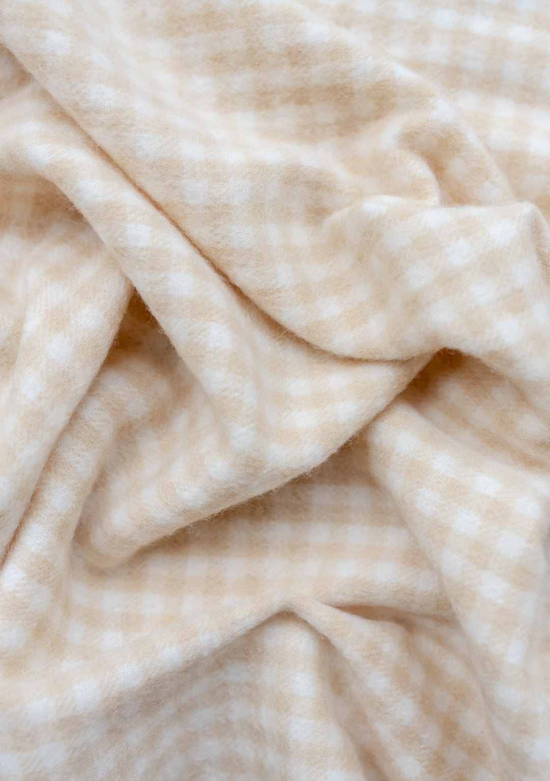 TBCo Lambswool Baby Blanket in Oatmeal Gingham pattern showing soft folds and texture of premium wool fabric