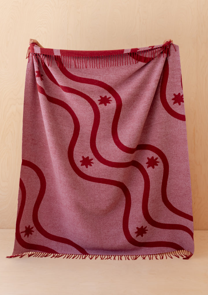 TBCo Lambswool Blanket in Red Wave Jacquard draped with fringed edges showcasing soft lambswool warmth and elegant design
