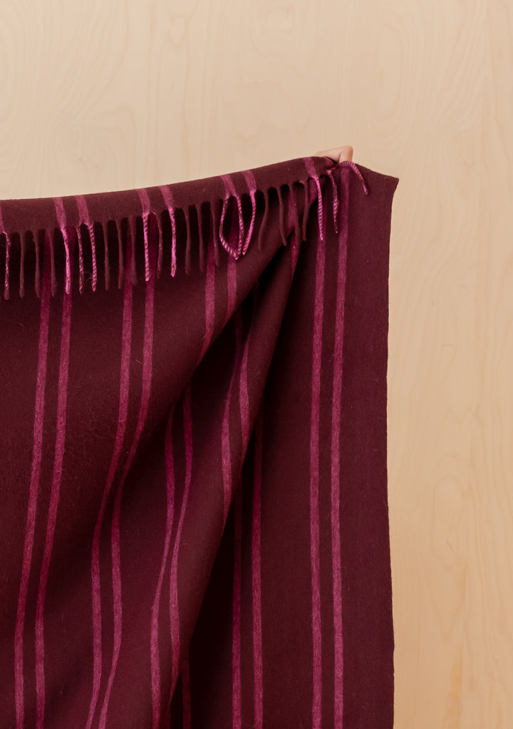 Close-up of TBCo Lambswool Blanket in Wine Stripe showing fringed edge and rich burgundy colour with pink pin stripes