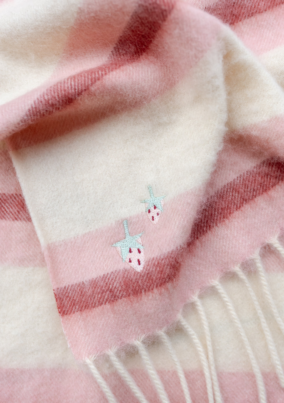 TBCo Lambswool Baby Blanket in Pink Stripe with embroidered sun and moon detail, featuring soft pink and cream stripes and fringed edges