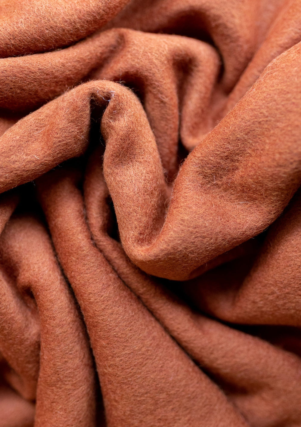 Luxuriously soft TBCo Lambswool Blanket in Rust Melange, showing detailed folds and texture of premium wool fabric