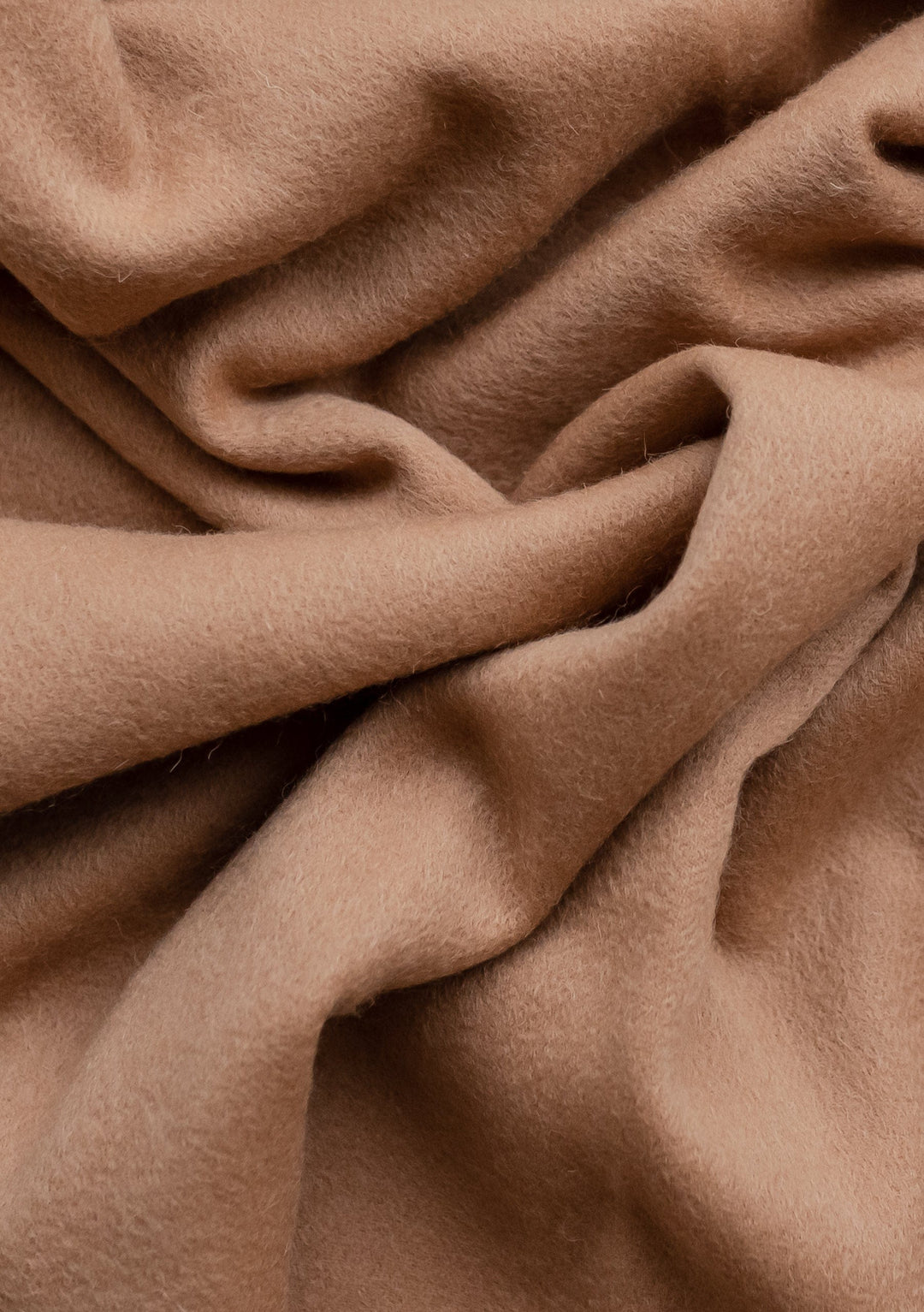 Soft, luxurious TBCo Lambswool Blanket in Camel shown with elegant folds highlighting the natural texture of premium wool fabric