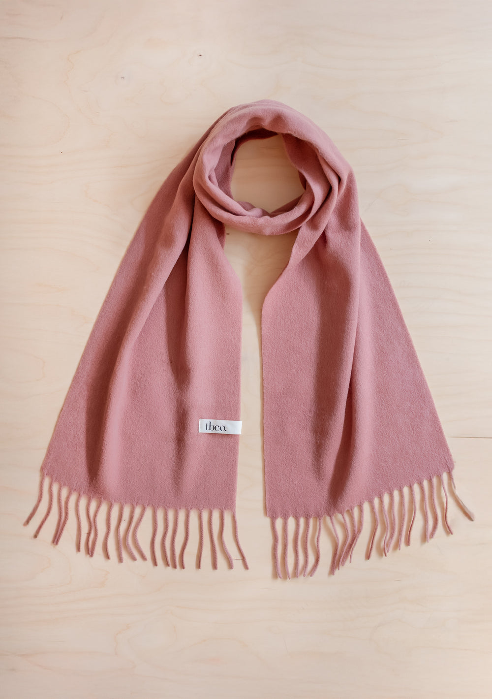 Lambswool Scarf in Blush by TBCo displayed flat with fringed edges in soft blush pink lambswool fabric