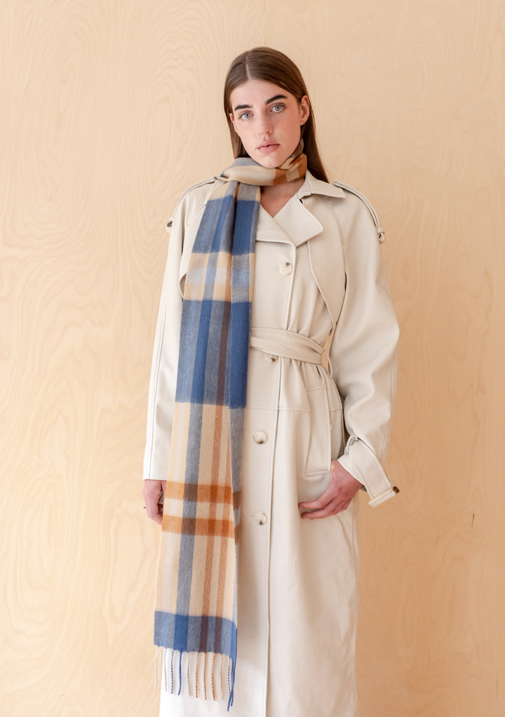 Model wearing TBCo Lambswool Skinny Scarf in Camel Modern Tartan draped over a beige trench coat