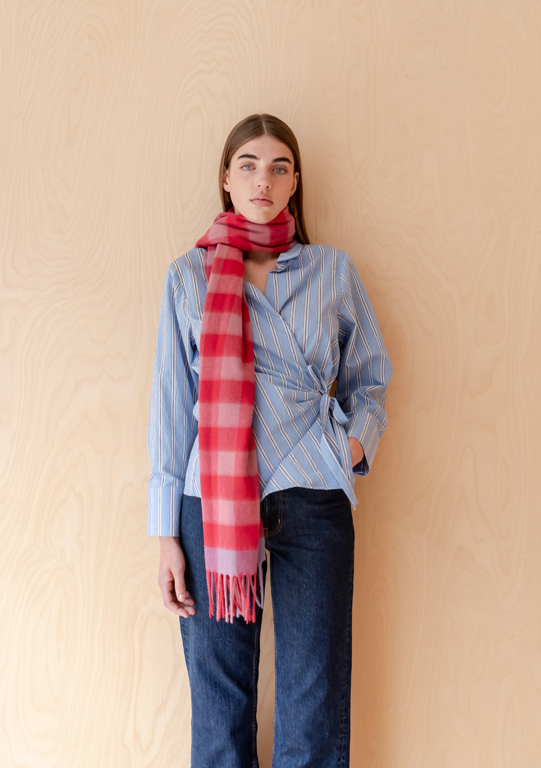 Model wearing a TBCo Lambswool Oversized Scarf in Rose Gingham styled with striped blouse and dark jeans