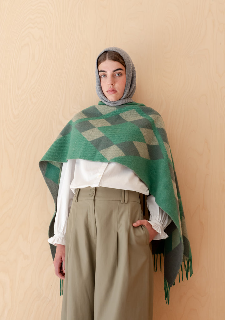 Woman wearing TBCo Lambswool Oversized Scarf in Green Diamond Jacquard styled with blouse and tailored trousers
