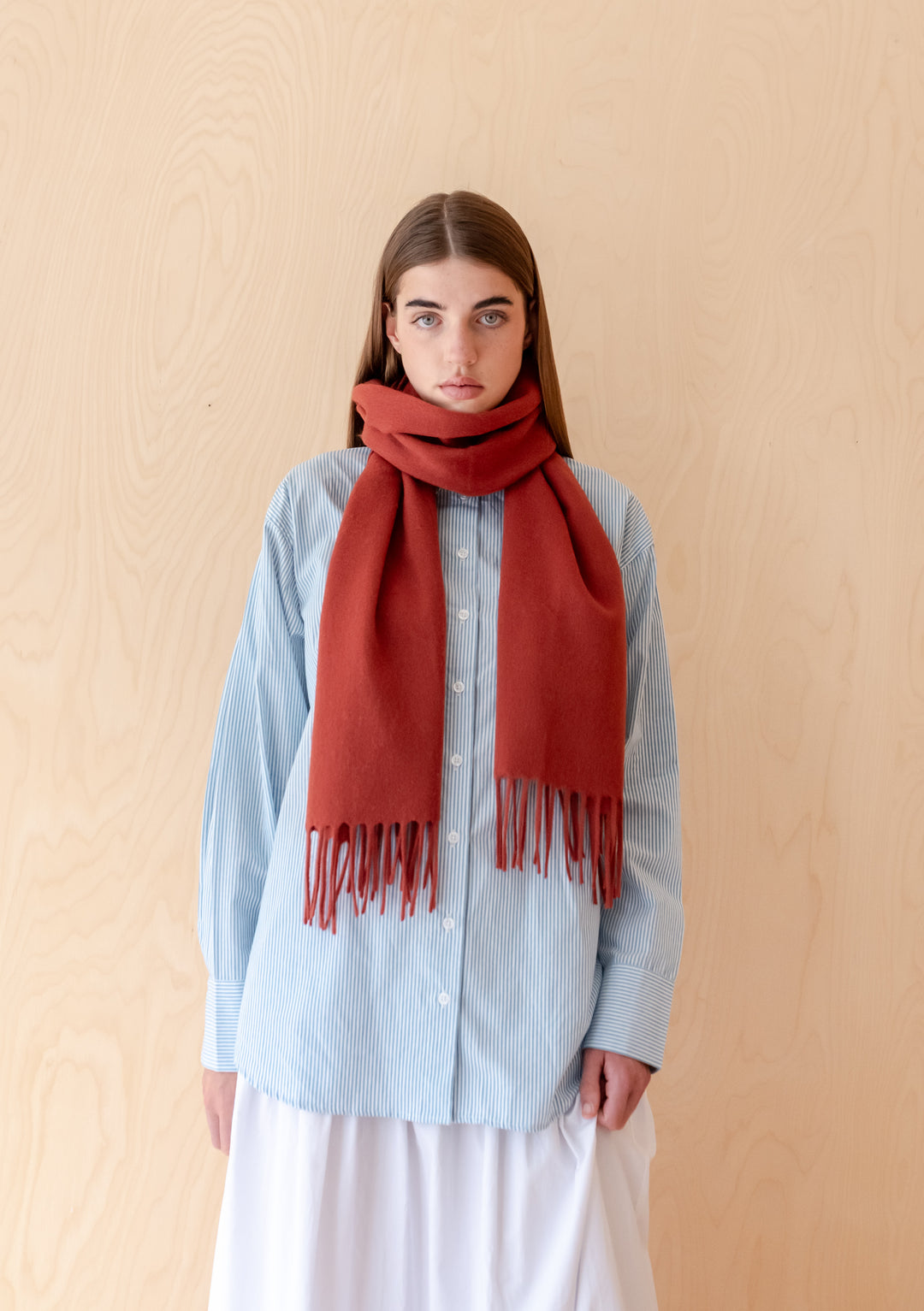 Model wearing TBCo Lambswool Oversized Scarf in Mulberry with fringed edge styled over a blue shirt and white skirt