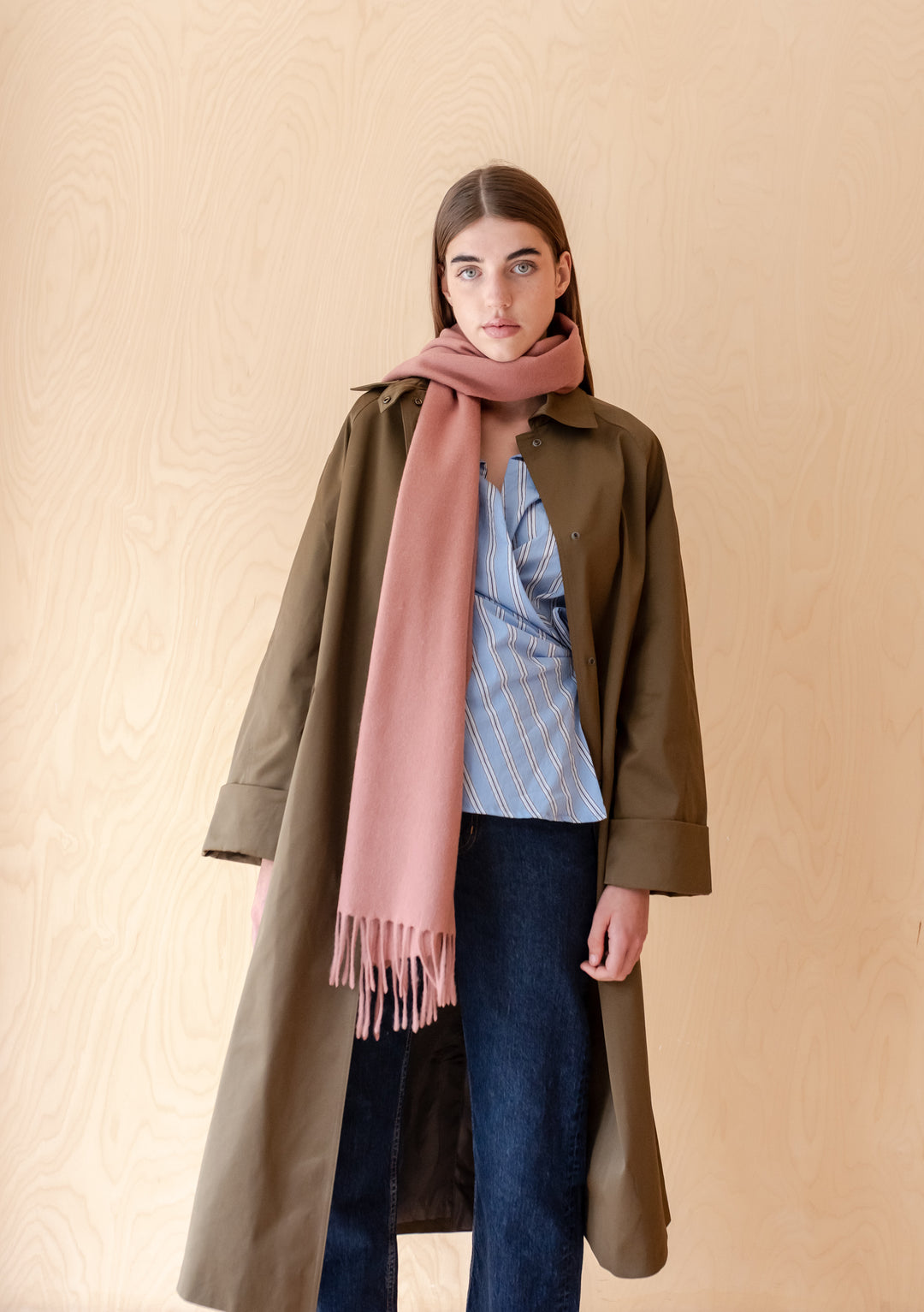 Woman wearing TBCo Lambswool Oversized Scarf in Blush styled with a coat and casual outfit against neutral background