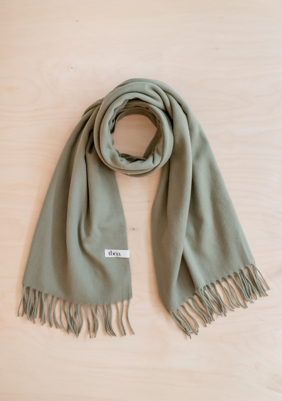 Soft Lambswool Blanket Scarf in Olive by TBCo with fringed edge, perfect for warmth and style.