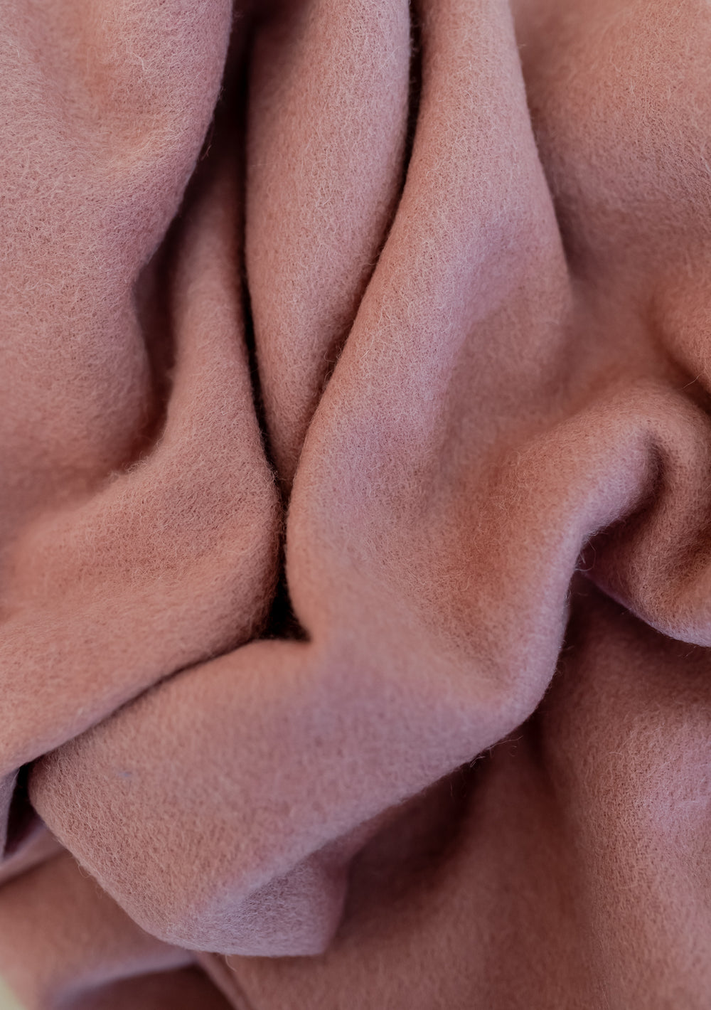 Close-up of soft lambswool fabric texture in blush pink for the TBCo Lambswool Blanket Scarf in Blush.