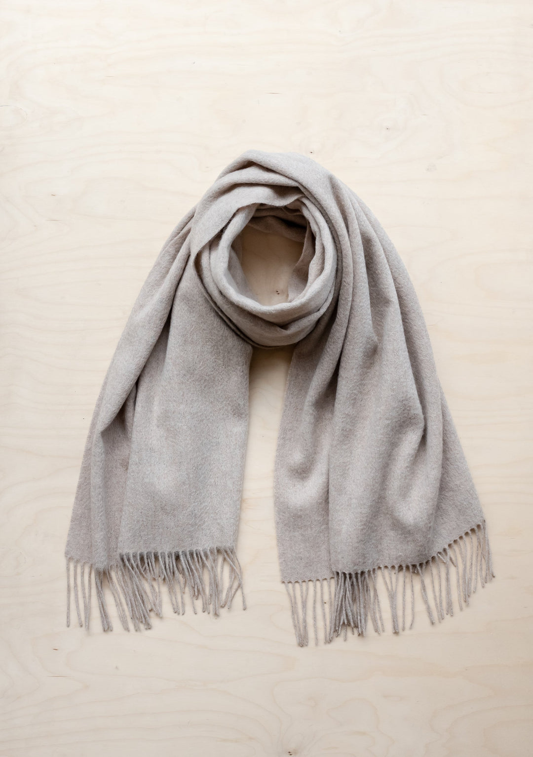 TBCo Lambswool Blanket Scarf in Oatmeal Melange with fringed edges, elegantly draped to showcase soft texture and natural colour