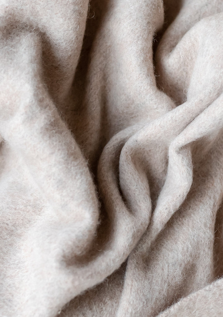 Soft folds and texture detail of TBCo Lambswool Baby Blanket in Oatmeal Melange showing natural wool fibres