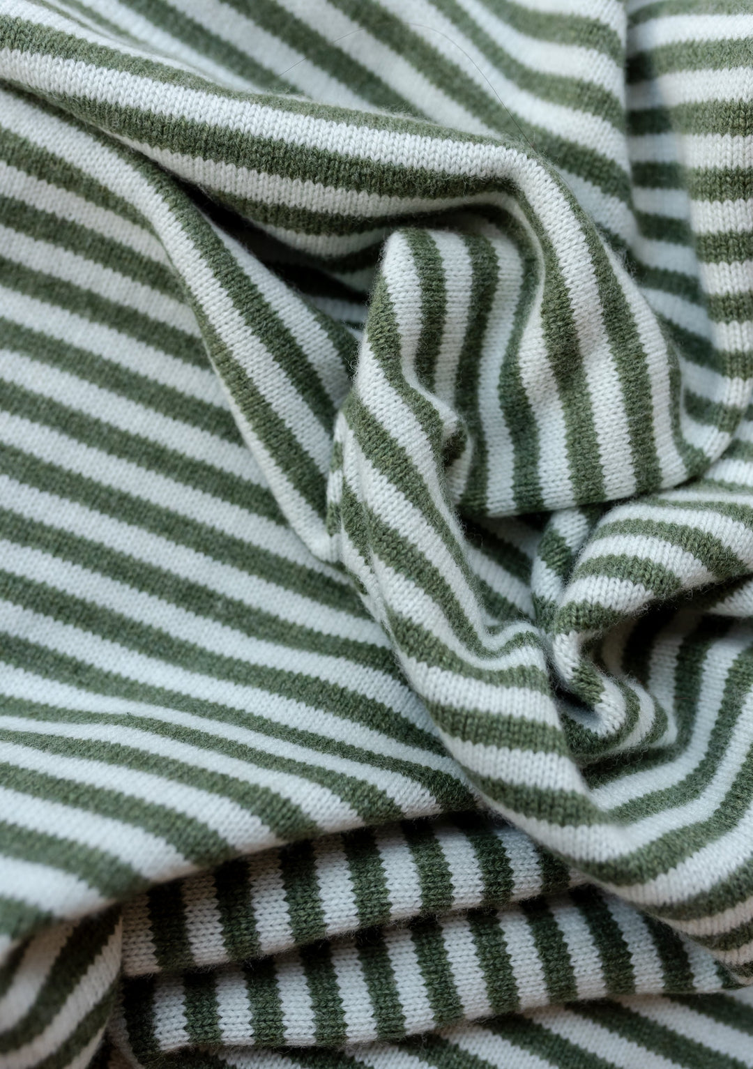 TBCo Large Merino Triangle Scarf in green and white stripes, showcasing soft knitted texture and premium wool fabric detail