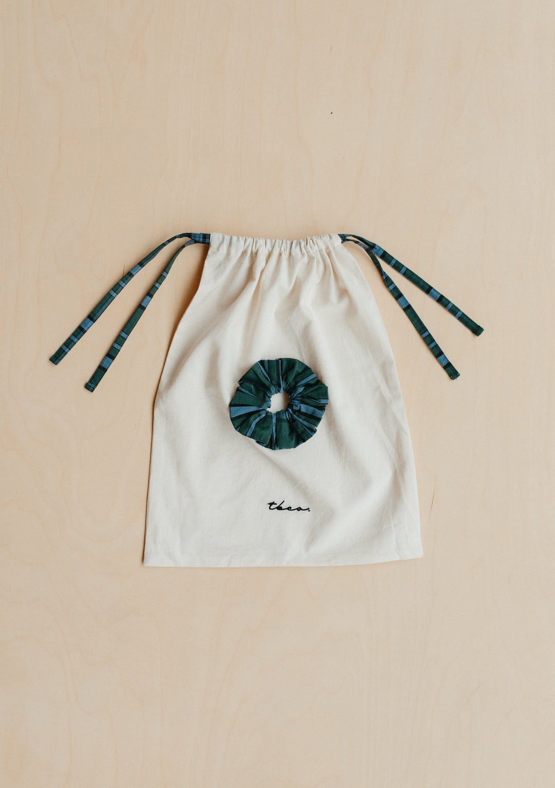 Cotton Pyjamas in Green Tartan matching scrunchie and drawstring bag by TBCo on wood background