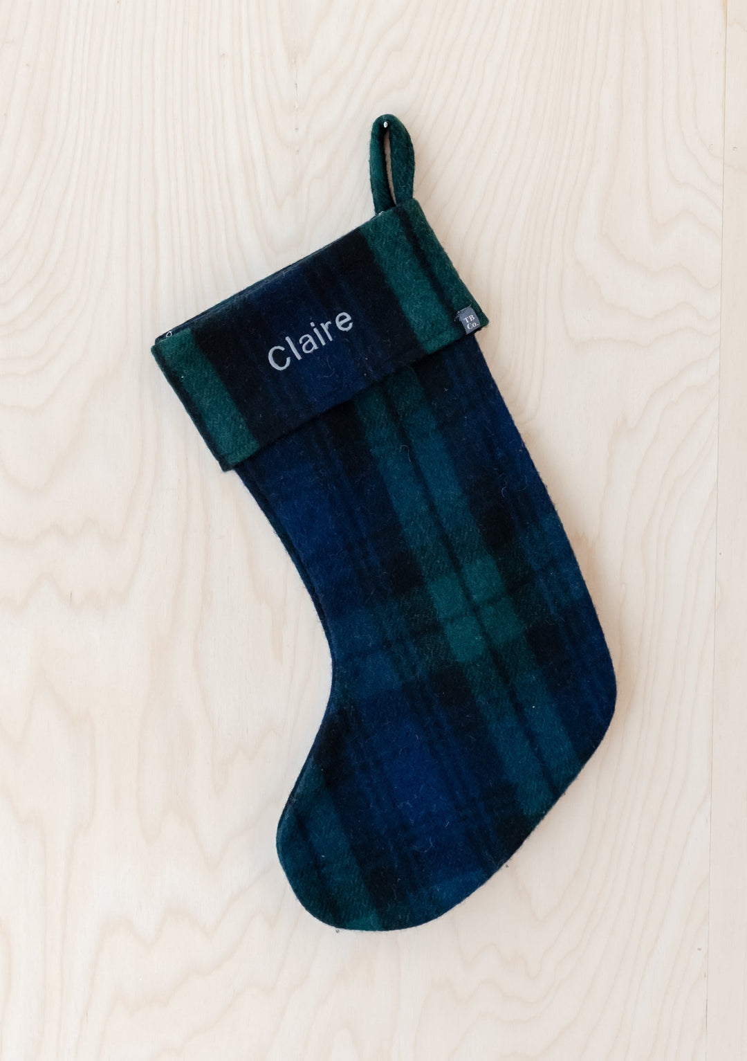 Personalised TBCo recycled wool Christmas stocking in blue and green tartan plaid with embroidered text showing embroidery service