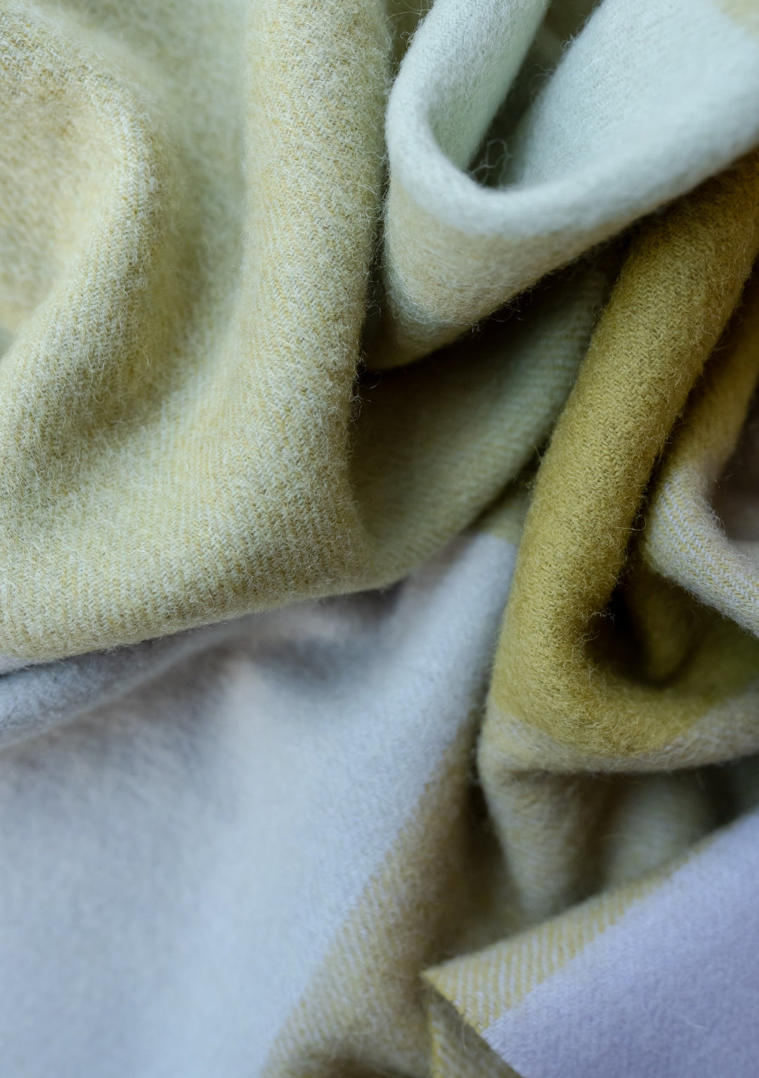 TBCo Lambswool Oversized Scarf in Sage Block Check featuring soft folds of sage and lavender wool textile close-up