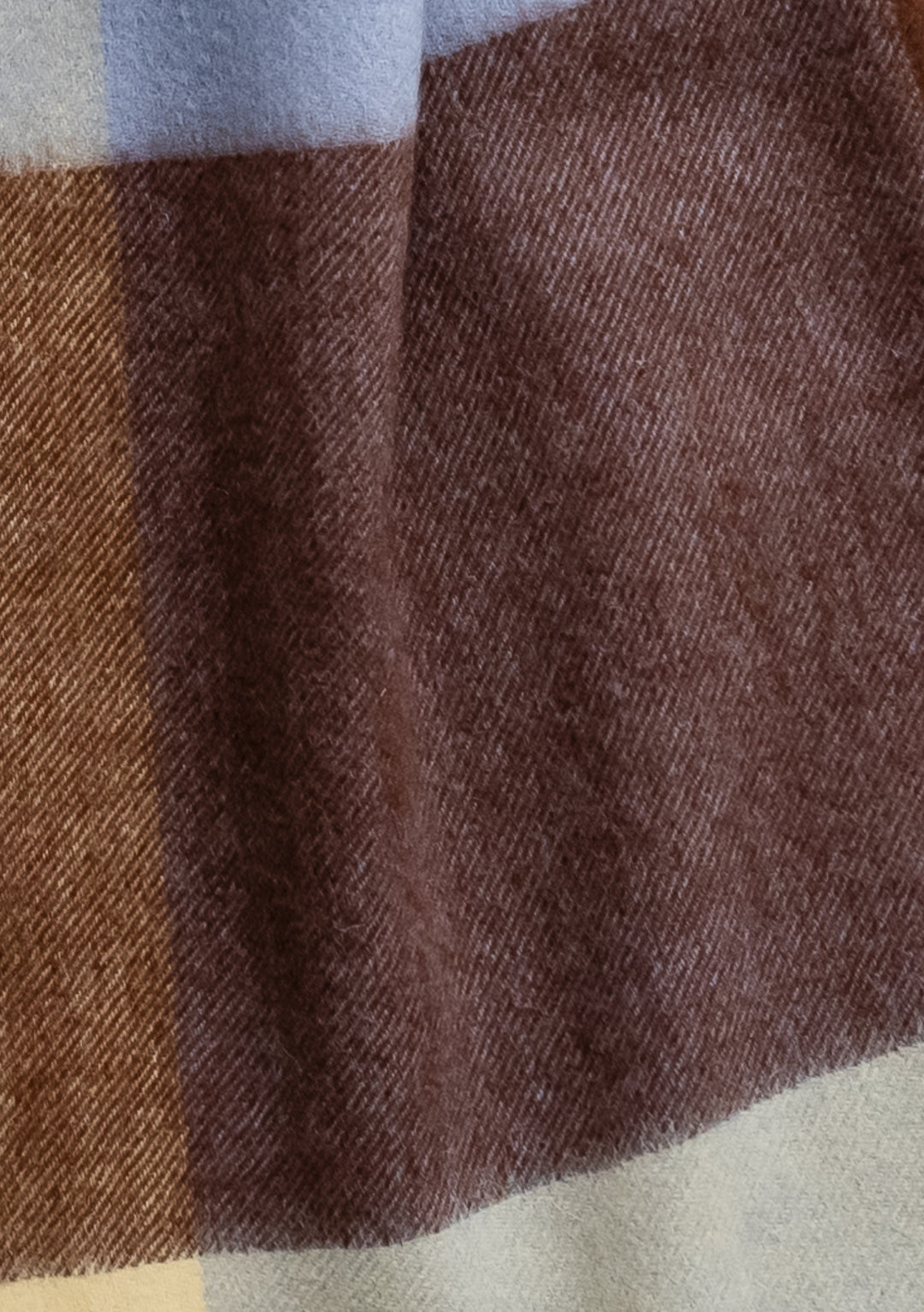 Close-up detail of TBCo Lambswool Oversized Scarf in Lilac Edge Check showing chocolate brown and lilac plaid pattern texture