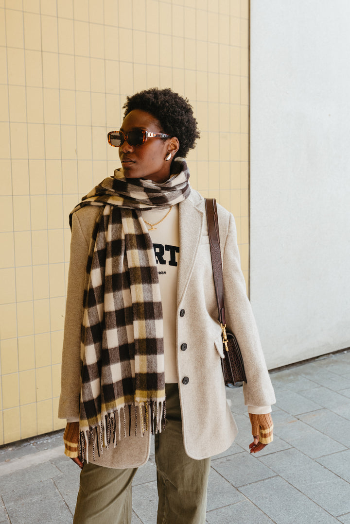 Stylish TBCo Lambswool Blanket Scarf in Monochrome Gingham styled with cream coat, displaying brown and grey check pattern with fringe detail