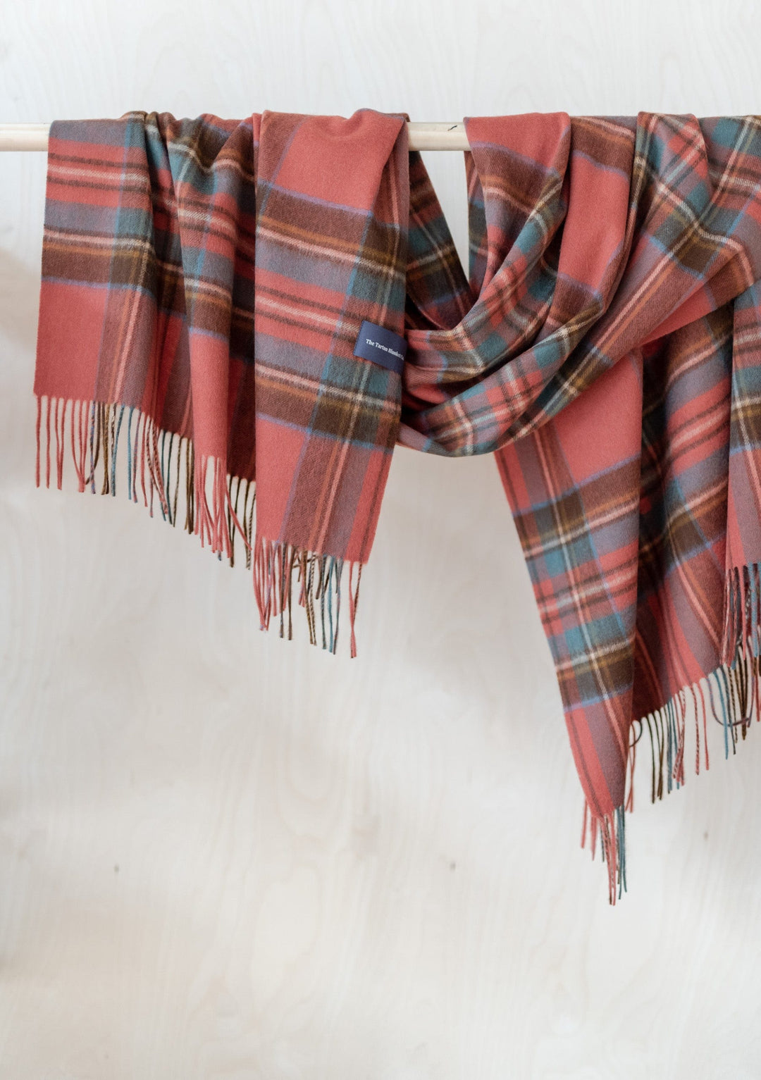 TBCo Stewart Royal Antique Tartan lambswool blanket scarf with fringing draped elegantly showing coral, blue and brown plaid pattern