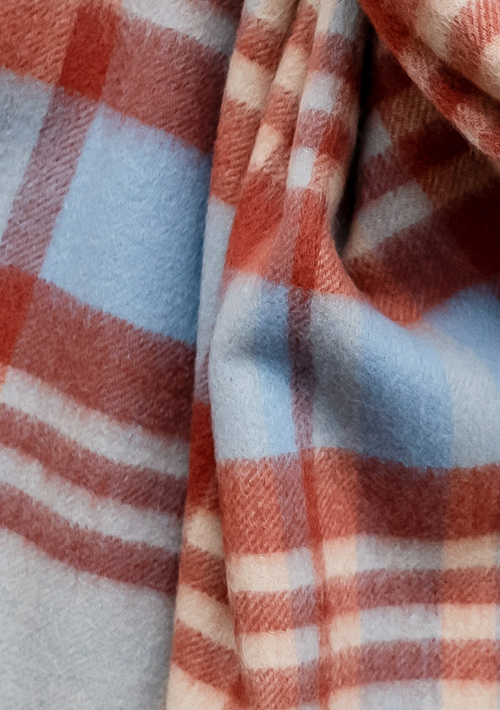 TBCo Lambswool Blanket Scarf in Blue Tartan Check featuring soft blue and clay red plaid pattern with fringed edges