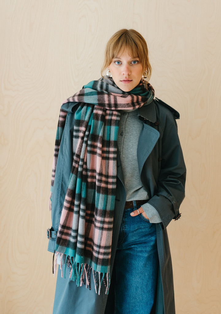 TBCo Lambswool Blanket Scarf in Green Tartan Check styled with teal coat and denim, showing fringed edges and plaid pattern