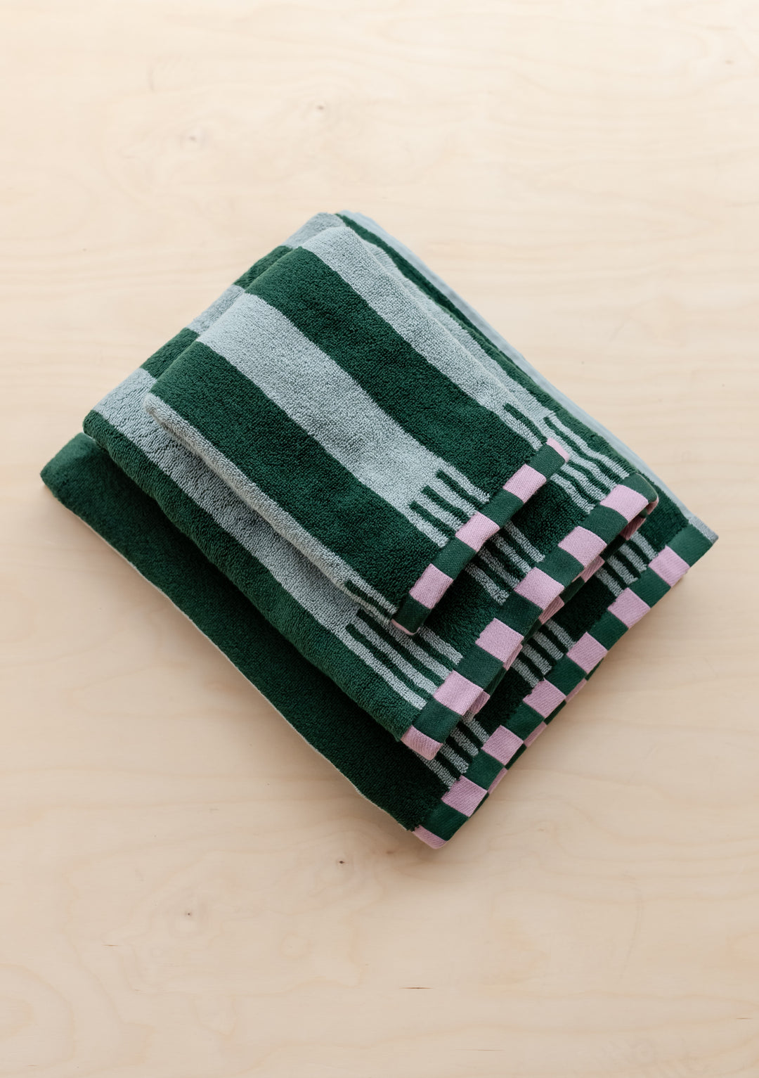 TBCo Terry Cotton Towels in Green Stripe stacked, showing plush texture with contrasting checkerboard edges.