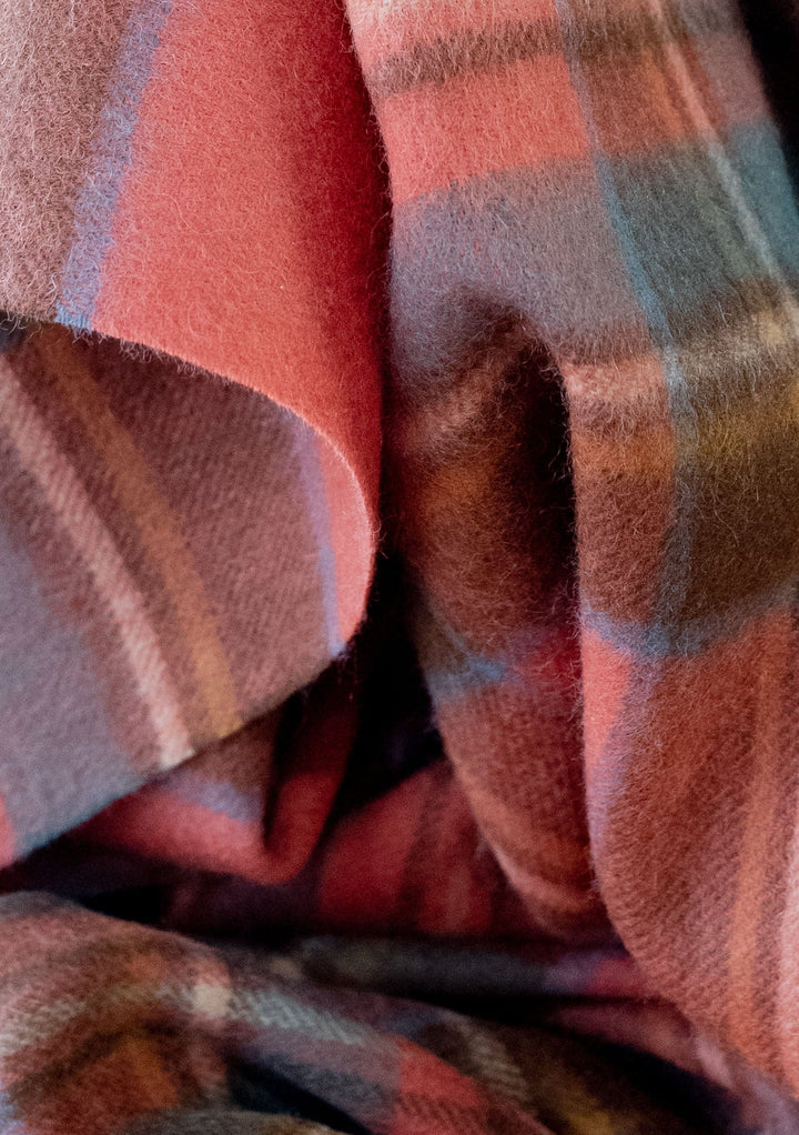 Close-up detail of TBCo lambswool blanket scarf in Stewart Royal Antique tartan showing soft textured folds and rich red tones