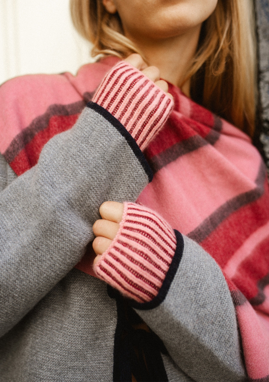 Woman wearing Cashmere & Merino Wrist Warmers in Burgundy Two-Tone by TBCo with layered knitwear in soft tones
