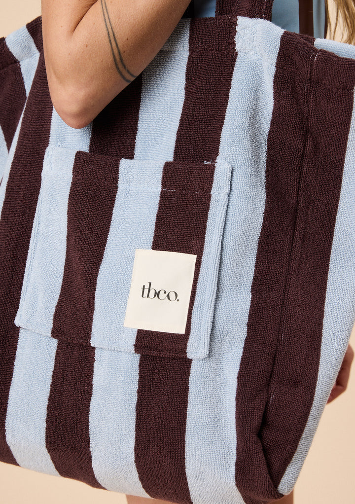 Close-up of TBCo Terry Cotton Tote Bag in Blue Stripe with soft terry fabric and front pocket featuring the TBCo logo patch