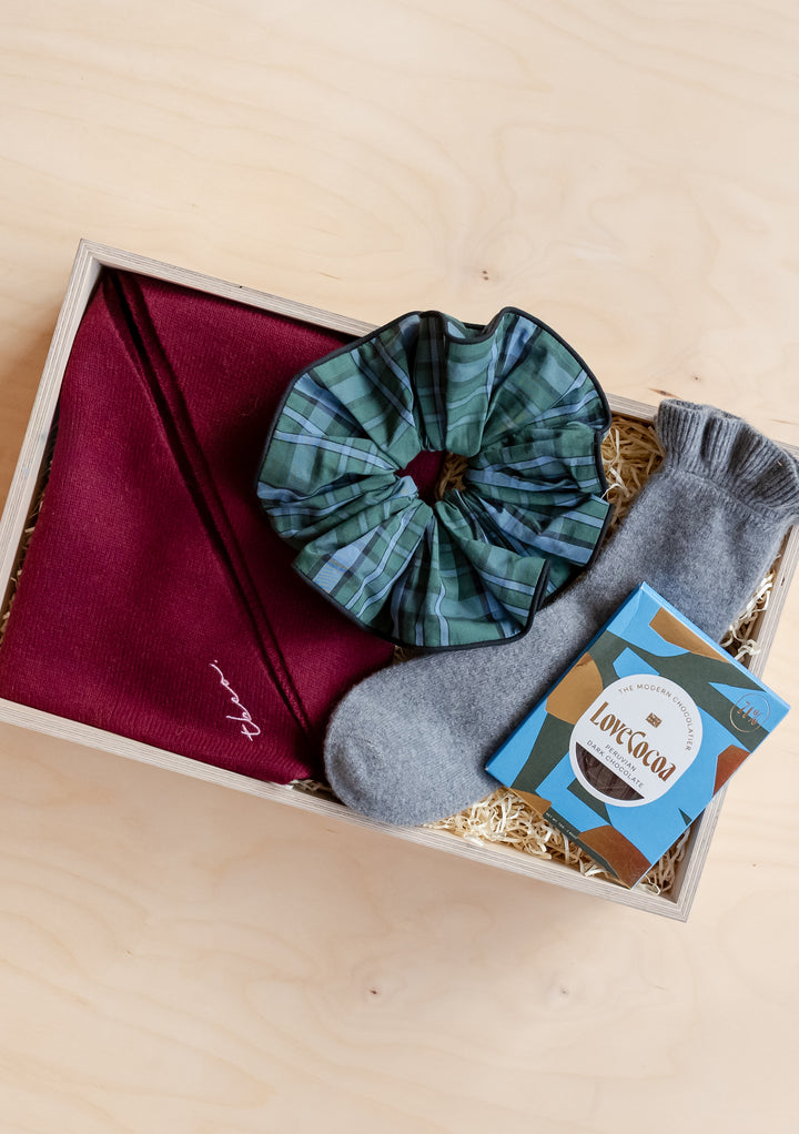 TBCo Accessories Gift Box with cozy grey socks, green tartan scrunchie, burgundy scarf, and luxury chocolate treat.