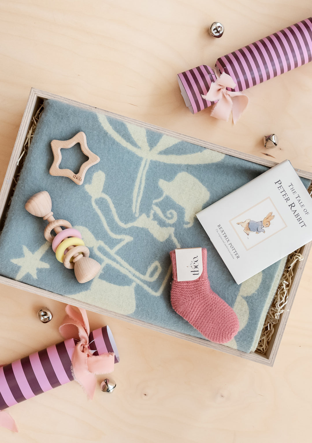 TBCo Baby Gift Box with soft blanket, wooden rattle, pink sock and Peter Rabbit book in eco-friendly wrapping.