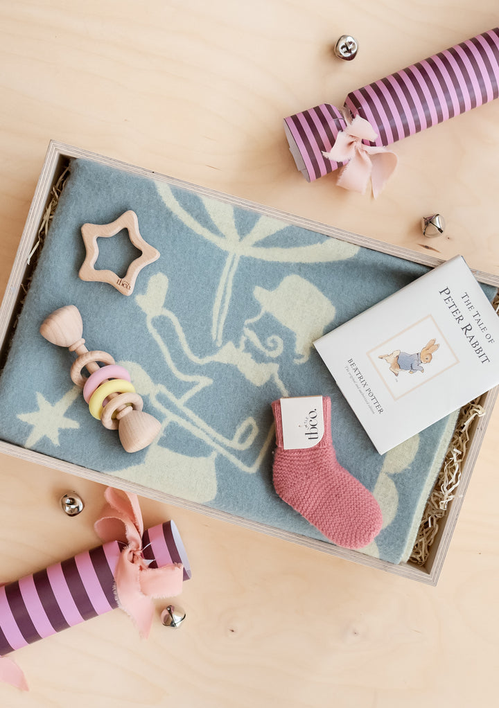 TBCo Baby Gift Box with soft blanket, wooden rattle, pink sock and Peter Rabbit book in eco-friendly wrapping.