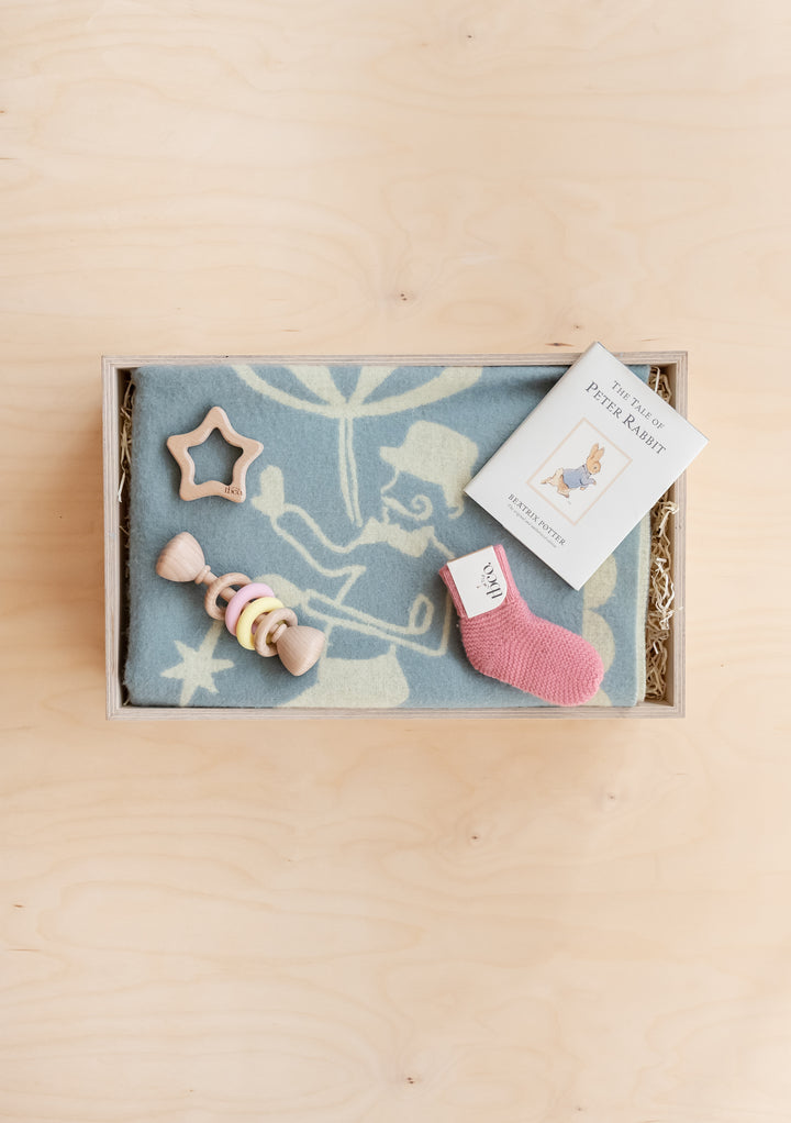 TBCo Baby Gift Box with blue blanket, wooden toys, pink sock, and The Tale of Peter Rabbit book in wooden display box