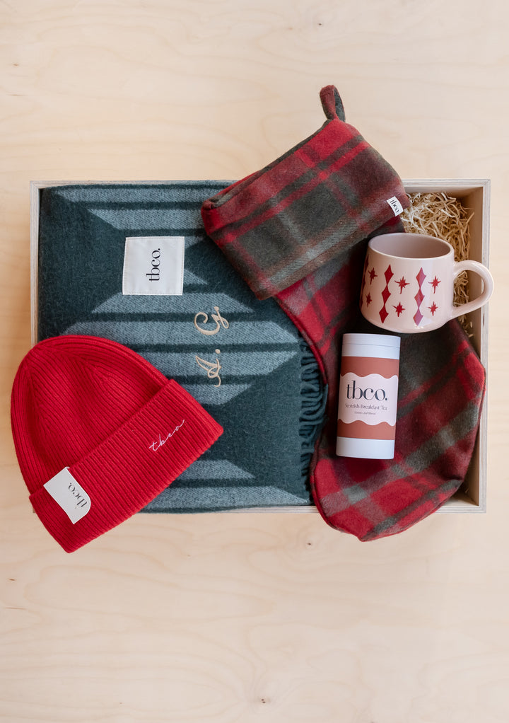 Build Your Own Christmas Gift Box by TBCo with cosy blanket, beanie, scarf, festive mug, and luxury hot chocolate.