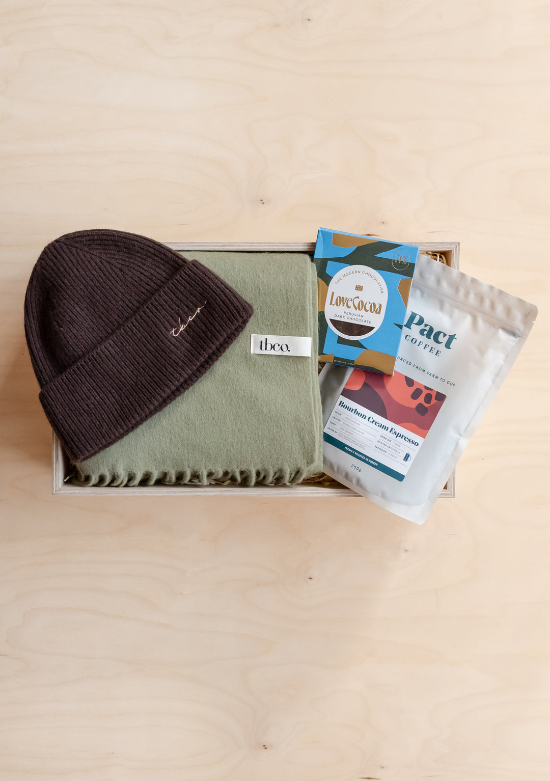 Gift Box For Him by TBCo featuring a brown beanie, green scarf, cocoa, and coffee in an elegant gift box.