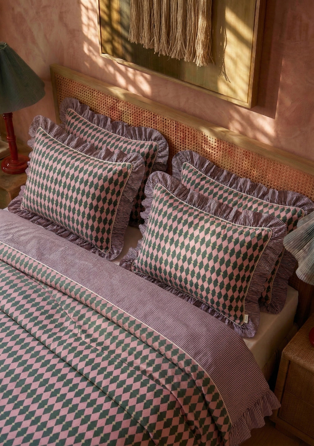 Pair of Cotton Pillowcases in Pink Harlequin by TBCo with pink and green diamond print and frilled edges on bed
