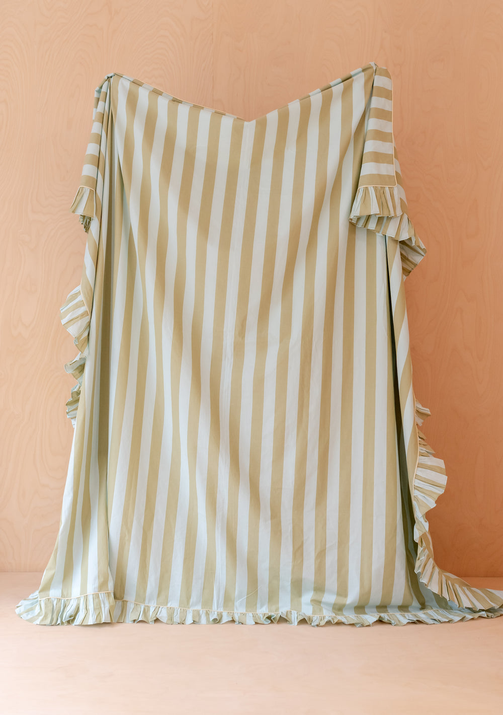 TBCo Cotton Duvet Cover & Pillowcases Set in Mint Stripe with subtle ruffles and soft vertical stripes hanging against pale wood wall