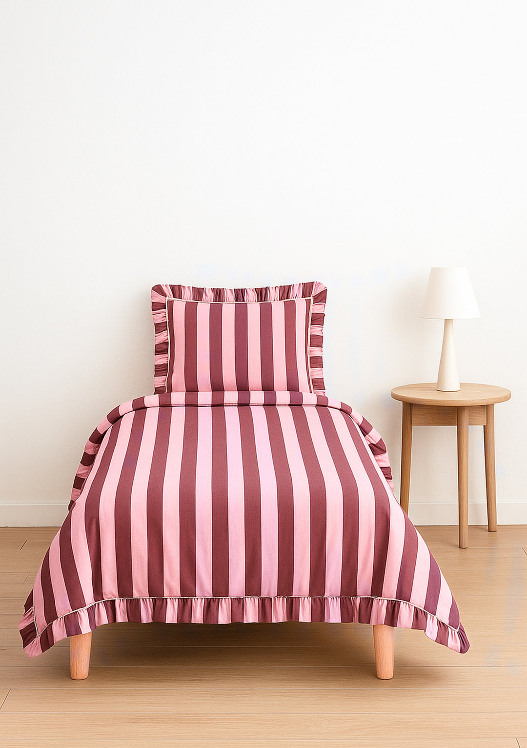 TBCo Cotton Duvet Cover & Pillowcases Set in Pink & Burgundy Stripe with ruffle edge on single bed in minimal bedroom