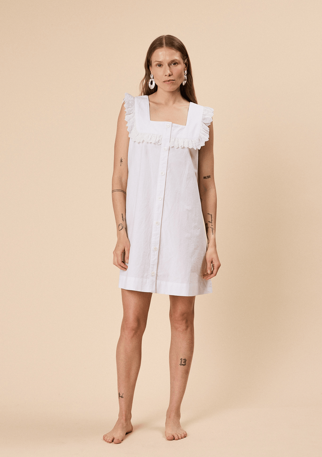 Woman wearing TBCo Cotton Broderie Sleeveless Dress in White with natural and recycled fibres, Certified B-Corp, designed to make an impact