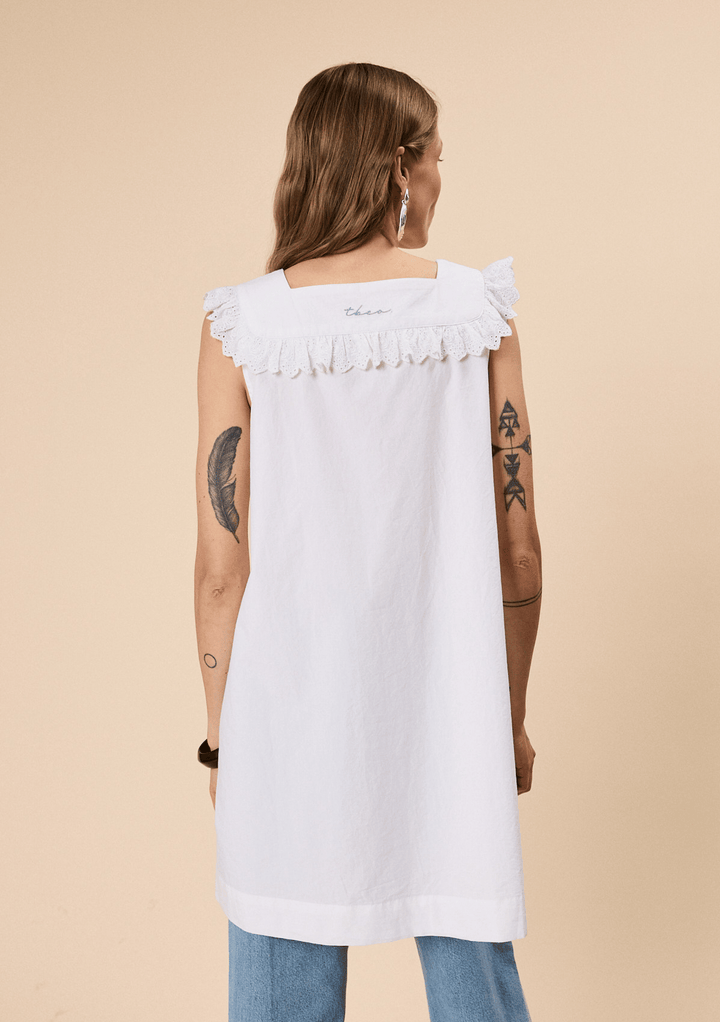Back view of woman wearing TBCo Cotton Broderie Sleeveless Dress in White with natural and recycled fibres, Certified B-Corp, women-founded, designed to make an impact