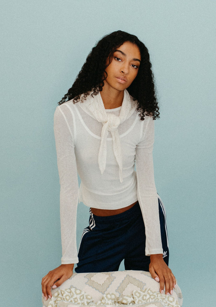 Model wearing TBCo Merino Wool Triangle Scarf in White Pointelle tied at the neck with light knit texture