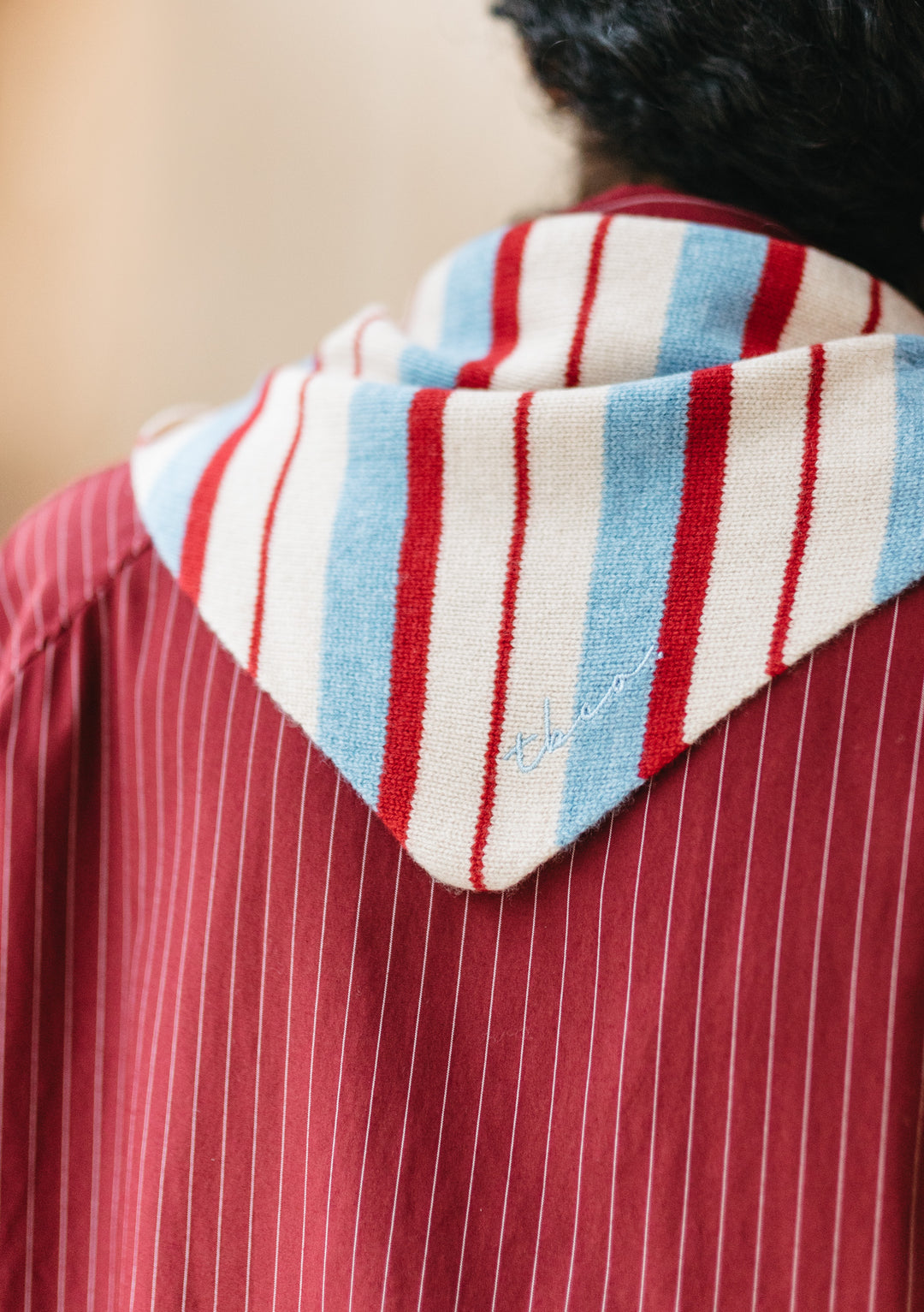 Back view of TBCo Merino Wool Triangle Scarf in Blue & Red Stripe with bold irregular stripes on a model's shoulders