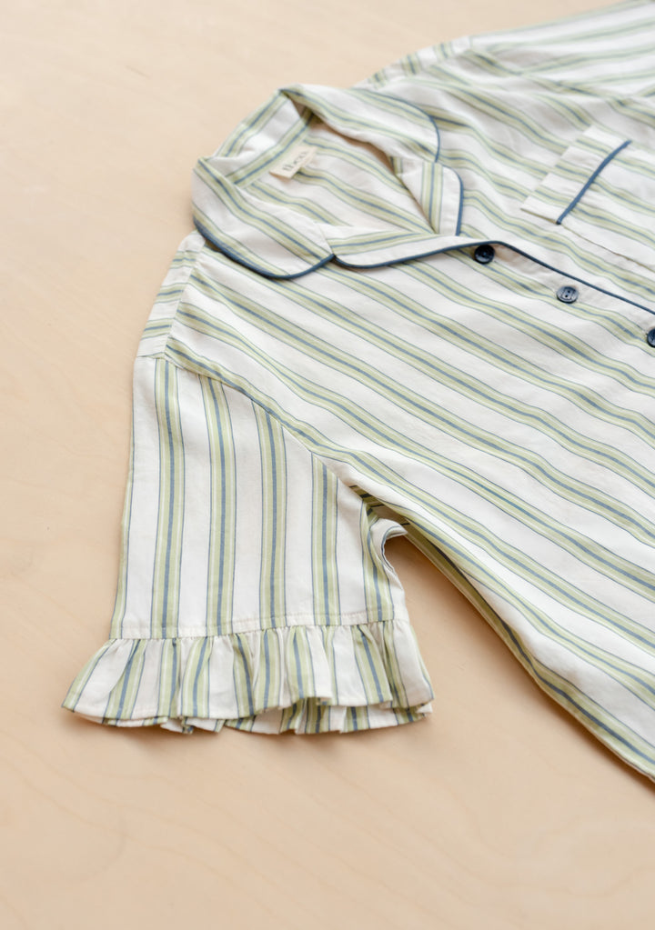 Close-up portrait of gallery position 7 showcasing TBCo Cotton Pyjamas in Olive Stripe Ruffle with delicate sleeve ruffle detail.