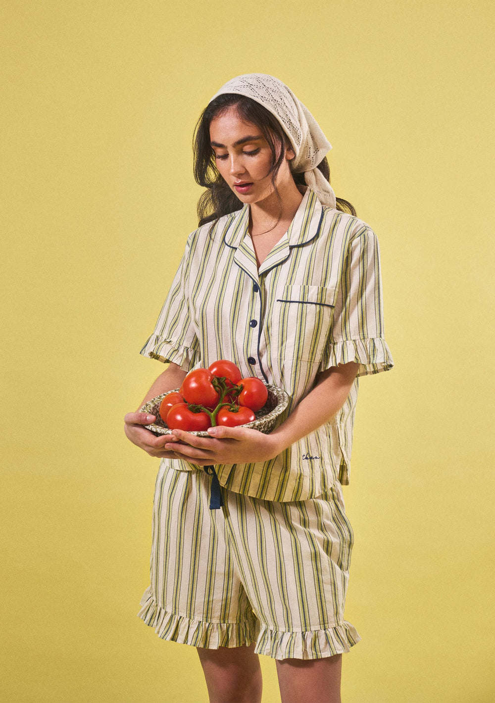 Woman wearing TBCo Cotton Pyjamas in Olive Stripe Ruffle holding tomatoes, portrait gallery position 2, 1803x2560px