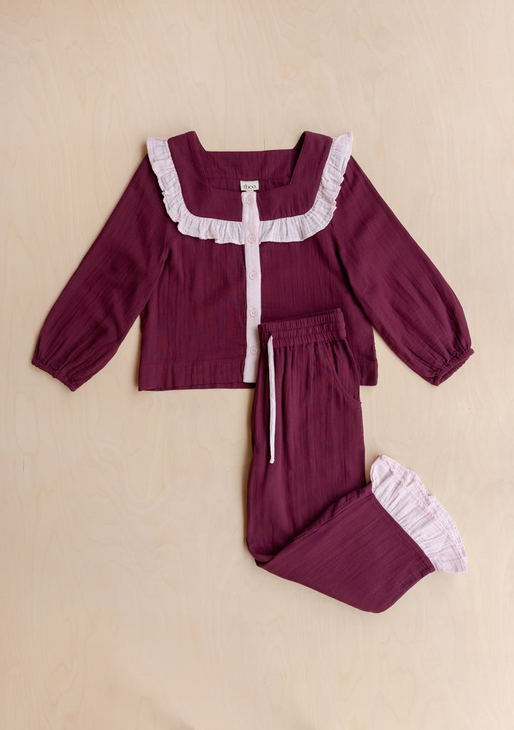 TBCo Cotton Pyjamas in Burgundy Ruffle: Soft pink two-piece set with light pink ruffles, button-front top, drawstring pants, and storage bag, designed in Edinburgh.