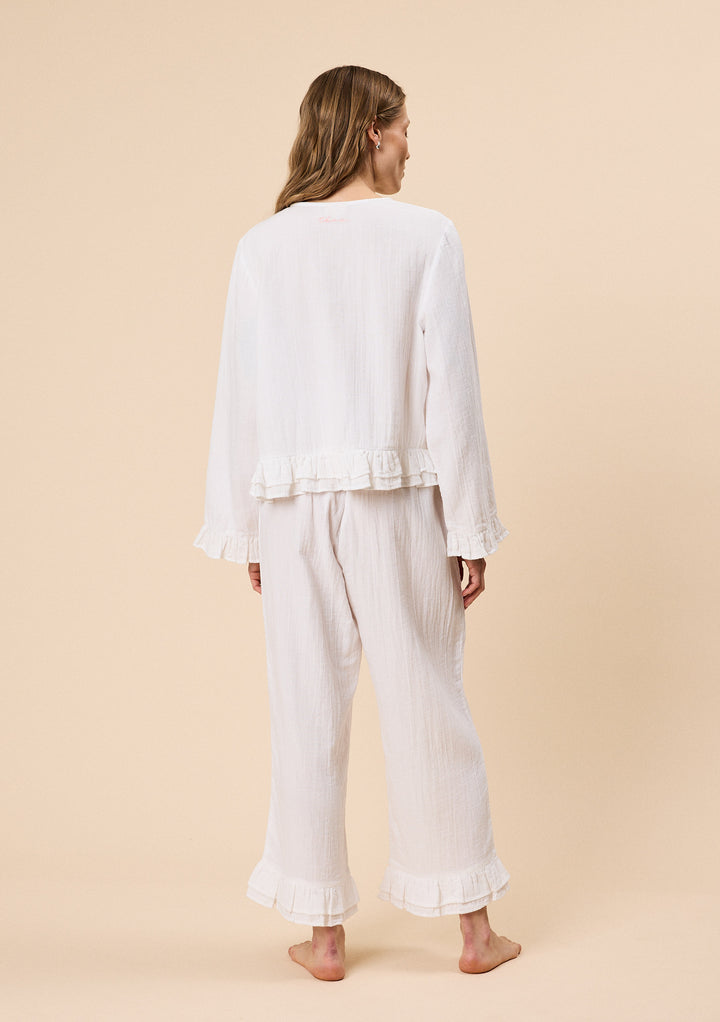 Back view of woman wearing TBCo Ankle Grazer Cotton Pyjamas in White Ruffle with natural and recycled fibres, Certified B-Corp, women-founded, designed to make an impact